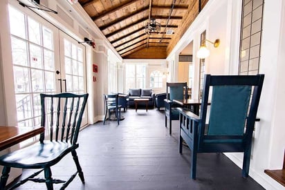 Graham's 318 in Geneva sun room patio dining space with blue and black chairs