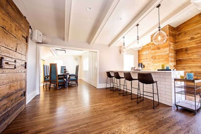 Business with white ceilings, hard wood flooring, and wooden decorative walls