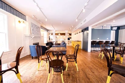 Restaurant dining space with multiple tables that seat 4 on the floor