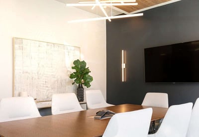 Conference office with a wall mounted TV, modern lights, white chairs