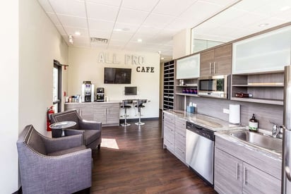 Employee breakroom with a full kitchenette and seating area at a company building