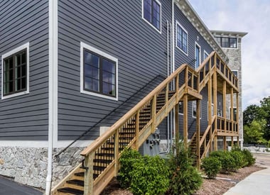 Back of a commercial building with a multi-tiered staircase wrapping around the back wall