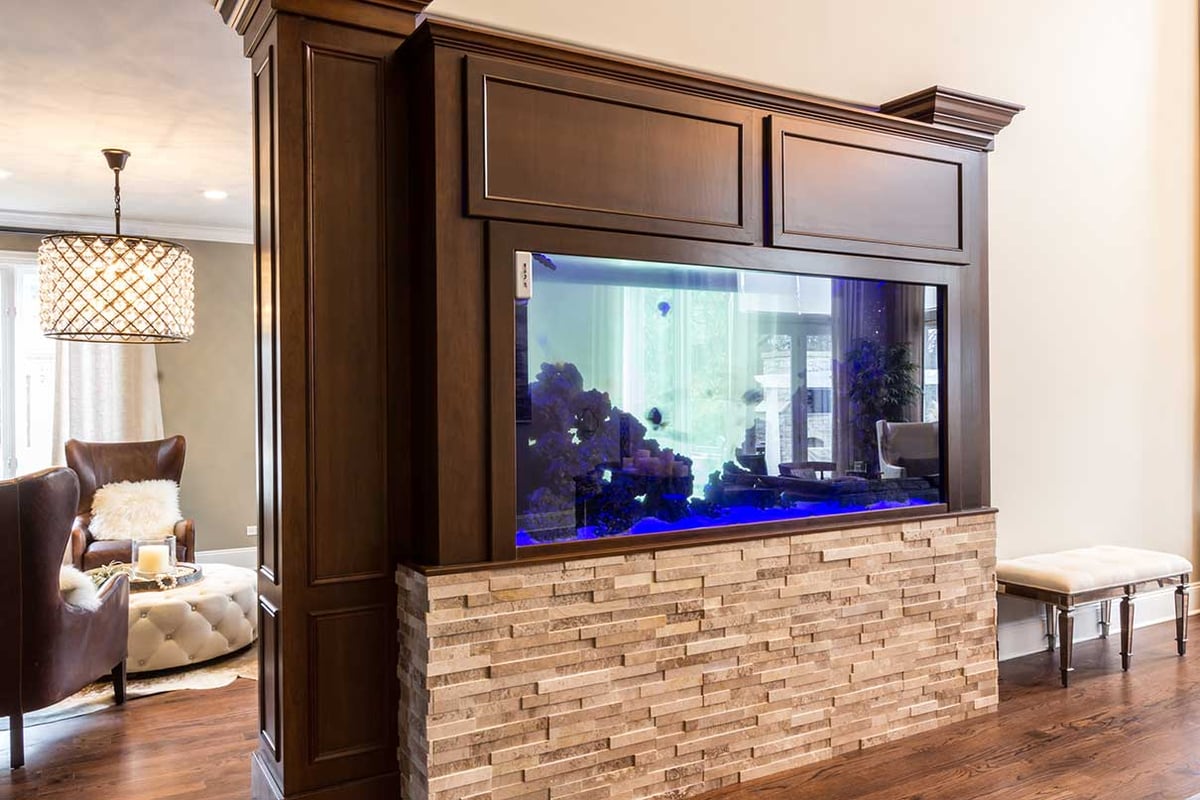Living room with a fish tank encased in a rich wooden enclosure