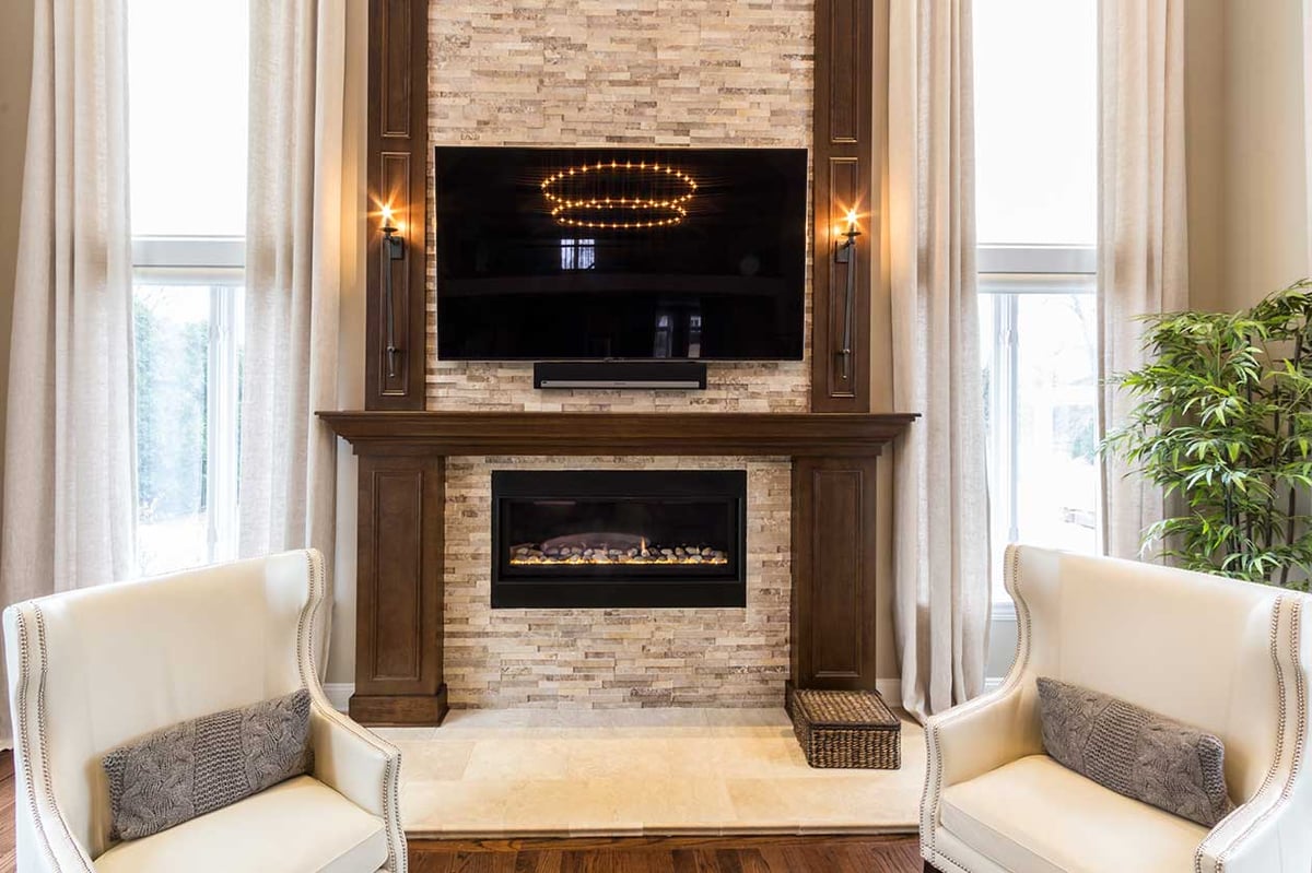 Fire place within a luxury family room with a television above 