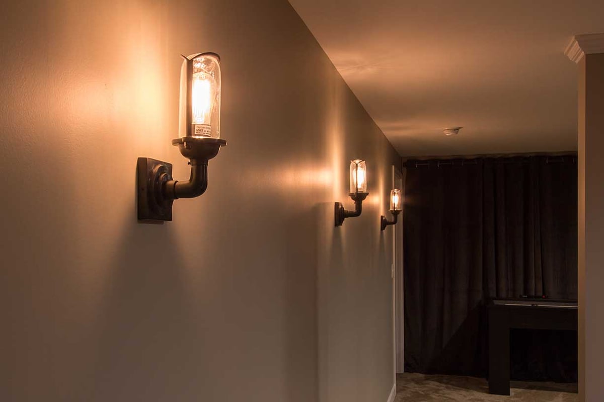 Industrial lighting in luxury basement remodel