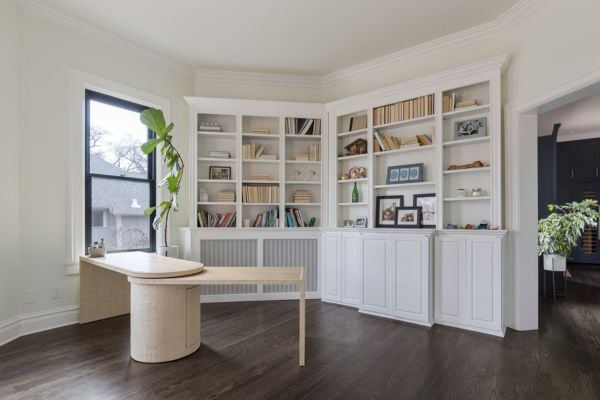 Home Office with white painted built-in shelving, wood floors and and linen and wood beige desk