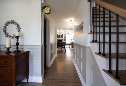 Front hallway from the front door with a table down the hall and a staircase on the right side