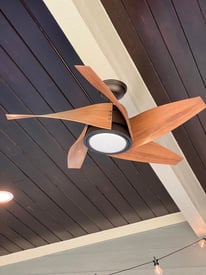 Outdoor ceiling fan with aesthetic blade and can lighting over a porch