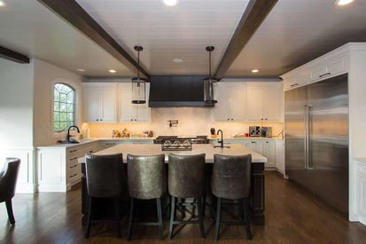 Kitchen island with four high-boy chairs on the opposite side for seating