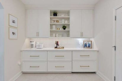 transitional room with white cabinets and drawers for lots of storage space and a small coffee bar on top of the counter