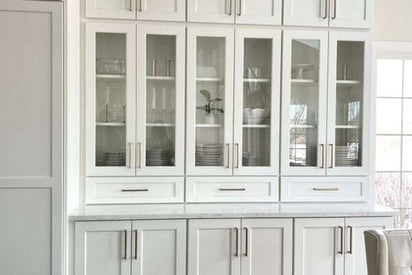 glass pane cabinetry with dinnerware and glasses visible from the outside