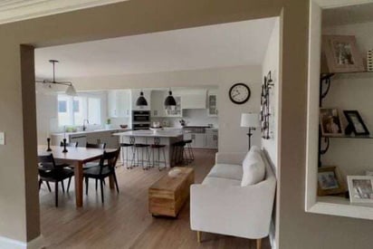 dining room and kitchen visible from a hallway with an open breezeway instead of double doors