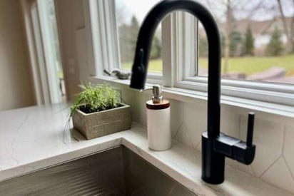 close up photo of a kitchen sink basin with a matte black kitchen faucet