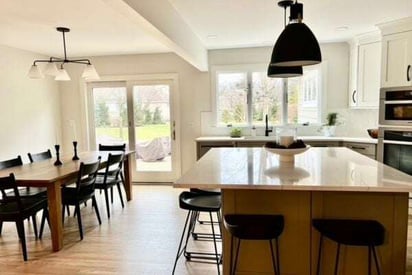 a kitchen and dining room looking out at the sliding patio door to the backyard