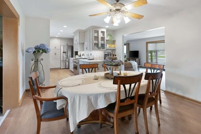 dining room with wooden chairs surrounding a table with a white cloth on it