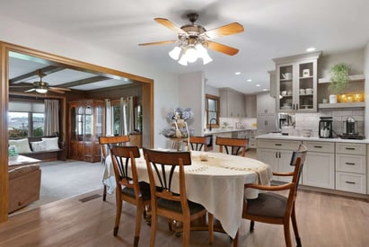 dining room with an open doorway to the family room and a ceiling fan