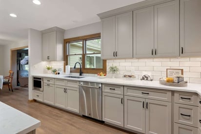 tons of kitchen cabinets lined up with an elegant white tile backsplash between