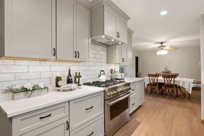 kitchen stove surrounded by cabinets and cooking necessities