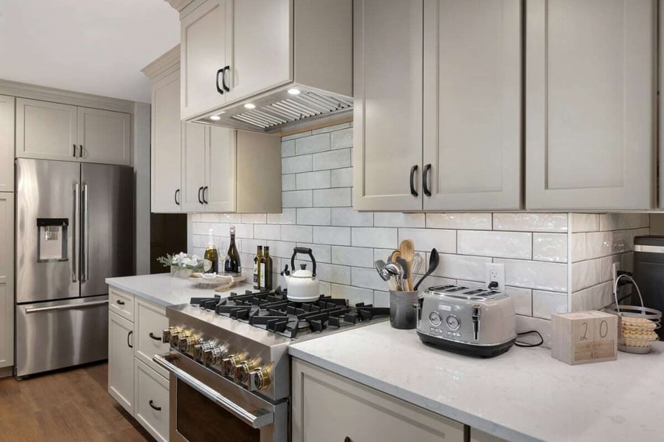 Luxurious kitchen remodel with a rectangle tile backsplash, stainless steel appliances, and quartz countertops