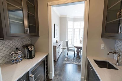 Small hallway looking into a dining room with a coffee bar on the left and a sink on the right