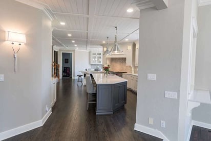 kitchen island with bar stool seating on the opposite side with wooden white farmhouse interior walls and ceilings