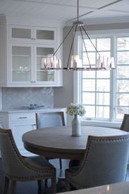 dining room table with four chairs that are grey and wooden with a chandelier above