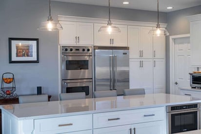 Kitchen island that seats four with bar stool high-boy chairs and 3 pendant lights