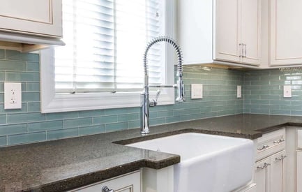 Kitchen sink faucet with a coiled head for easy use and a white ceramic basin