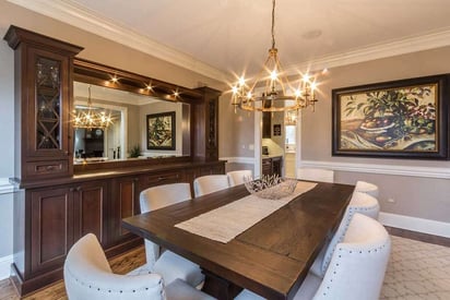 warm dining room illuminated by a soft white chandelier and white leather chairs