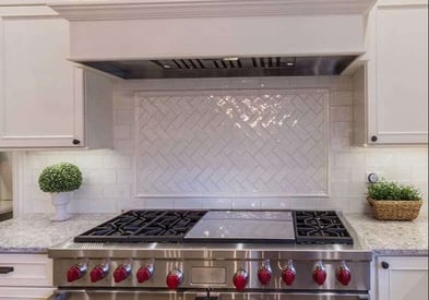 kitchen stove/range with red knobs and a white artistic backsplash