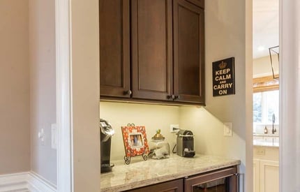 Mini coffee bar and brown kitchen cabinets for added storage space