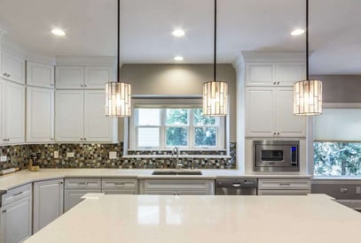 three modern and decorative pendant lights hung above a kitchen island