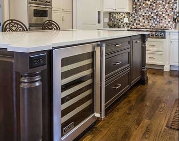 kitchen island with decorative end posts and a built in wine cooler