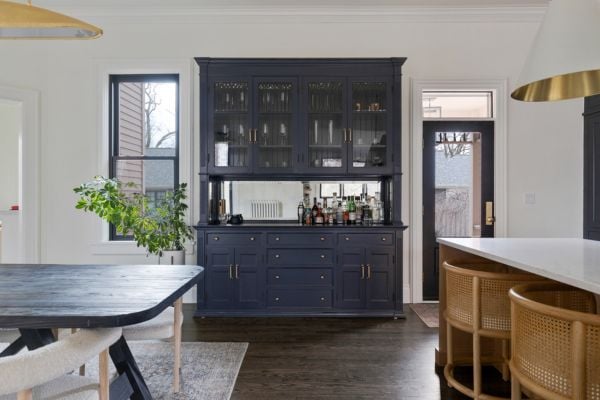 Kitchen navy hutch_bar with glass panel upper cabinets and gold hardware, featuring a mirrored back