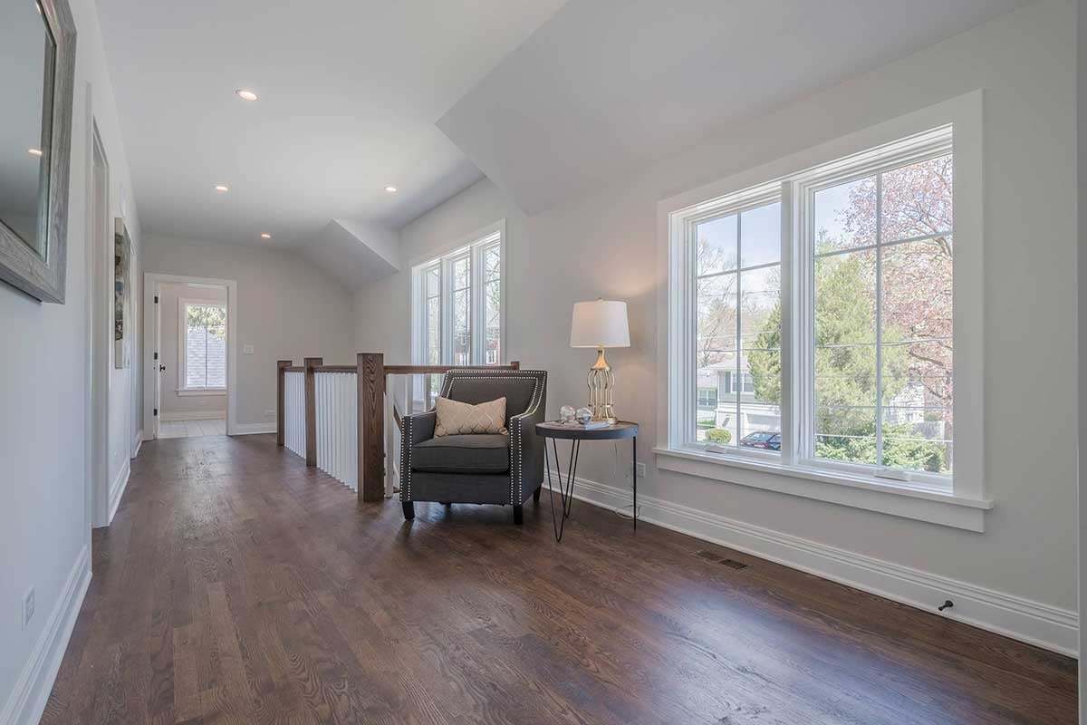 Second floor landing with rich wooden flooring and reading corner