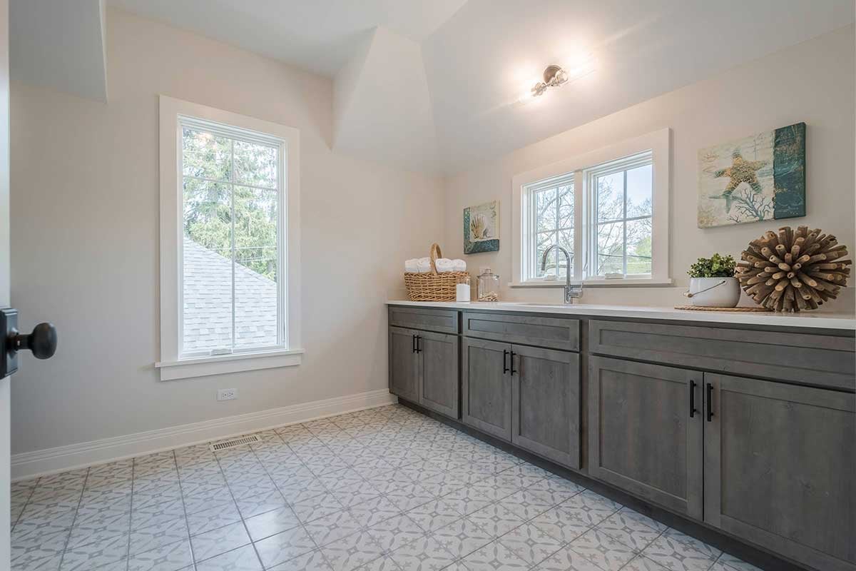 New home bathroom with white pattern tile flooring and wooden vanity cabinets