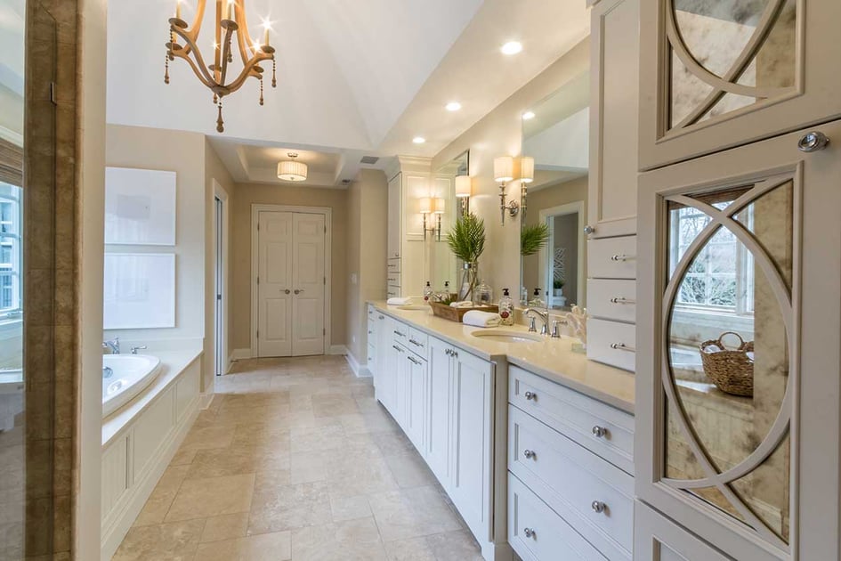 Luxurious bathroom with all white interior, a double vanity, and a built in tub separate from the shower