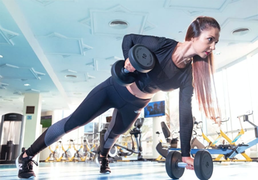 Woman at gym exercising and lifting weights