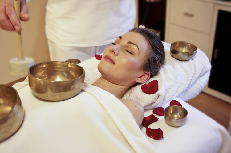 woman at spa with red rose petals and gold bowl