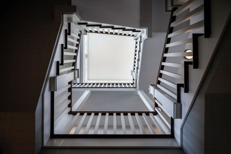 Spiral staircase with wooden banister and white poles