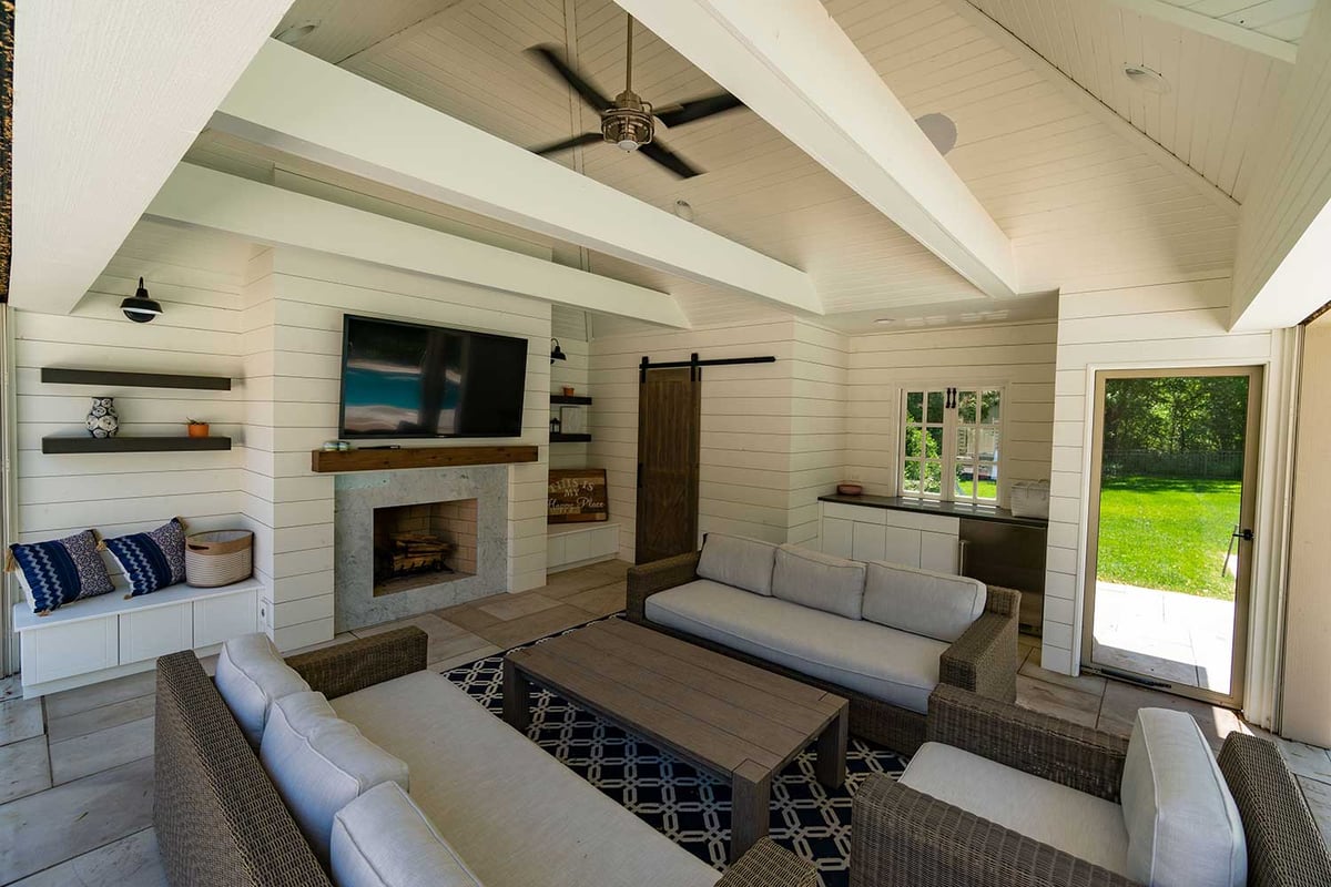 Pool house bungalow with integrated television and seating area for guests