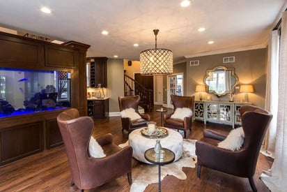 Living room seating area with large leather arm chairs and exotic white fur pillows