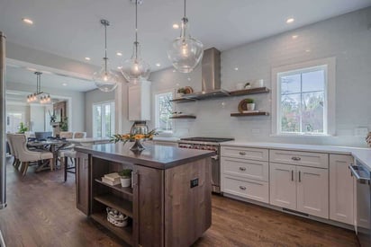 Bright kitchen remodel with a small island for prepping, stainless steel appliances, and a dining room in the background