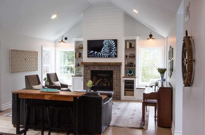 Living room with a cathedral ceiling and a wall mounted TV with a Zebra on it