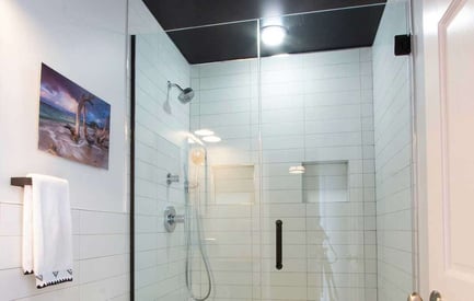 Shower with two sliding glass doors and white modern tile walls