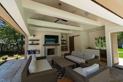 Pool house with a high ceiling, patio furniture set, and a wall mounted TV